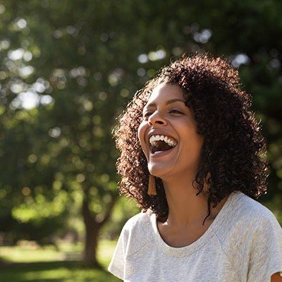 young woman curly hair laughing while 1687578475